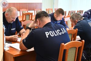 Zdjęcie kolorowe. Policjanci piszą test