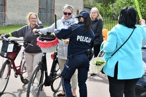 Zdjęcia kolorowe. Uczestnicy rajdu na rowerach witani są przez organizatorów. Każdy uczestnik otrzymuje element odblaskowy.