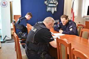 Zdjęcie kolorowe. Policjanci piszą test