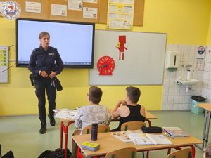 Zdjęcie kolorowe. Dzielnicowa rozmawia o bezpieczeństwie z uczniami