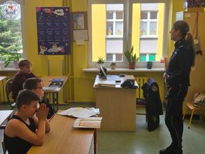 Zdjęcie kolorowe. Dzielnicowa rozmawia o bezpieczeństwie z uczniami