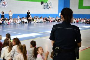 Zdjęcie kolorowe. Policjantka na apelu w sali gimnastycznej