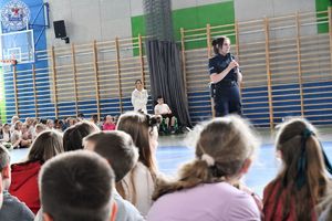 Zdjęcie kolorowe. Policjantka na apelu w sali gimnastycznej