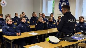 Zdjęcie kolorowe. Policjant ruchu drogowego na spotkaniu z uczniami