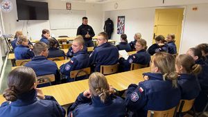 Zdjęcie kolorowe. Policjant ruchu drogowego na spotkaniu z uczniami