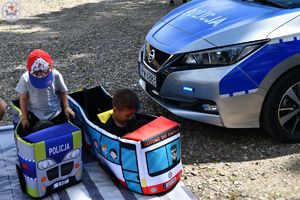 Zdjęcia kolorowe. Dzieci siedzą w małych edukacyjnych samochodzikach