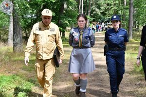 Zdjęcie kolorowe. Na zdjęciu harcerka policjant i strażak