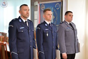 Zdjęcie kolorowe. Policjanci w mundurach wyjściowych przed wręczeniem aktów mianowania na stopień podkomisarza Policji