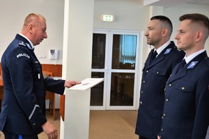 Zdjęcie kolorowe. Komendant wręcza akt mianowania
