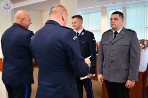 Zdjęcie kolorowe. Komendant wręcza akt mianowania