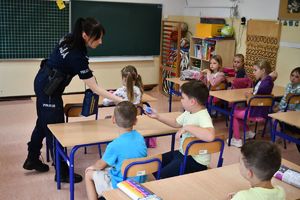 Zdjęcie kolorowe. Policjantka podczas spotkania z uczniami