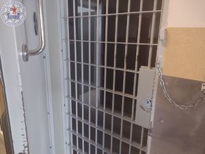 Zdjęcie kolorowe. Kraty w pomieszczeniu dla osób zatrzymanych