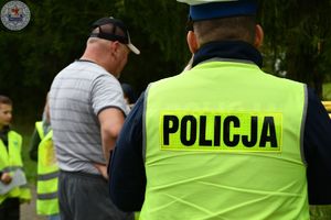 Zdjęcie kolorowe. Uczniowie rozmawiają z kierowcą