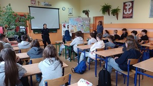 Zdjęcie kolorowe. Policjantka na spotkaniu w szkole z uczniami