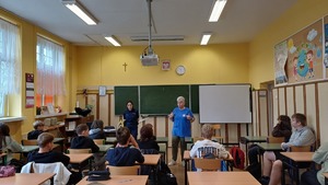 Zdjęcie kolorowe. Policjantka na spotkaniu w szkole z uczniami
