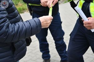 Zdjęcie kolorowe. Policjanci ruchu drogowego rozdają odblaski przechodniom
