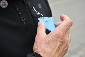 Zdjęcie kolorowe. Policjanci ruchu drogowego rozdają odblaski przechodniom