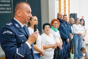 Zdjęcie kolorowe. Komendant Powiatowy Policji w Szczecinku przemawia podczas wydarzenia profilaktycznego w szkole