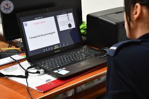 Zdjęcie kolorowe. Laptop na ekranie którego wyświetlony jest napis handel ludźmi