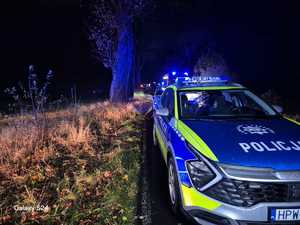 Zdjęcia kolorowe. Zdjęcia zrobione nocą. Na jednym pasie ruchu stoją zaparkowane pojazdy służb.