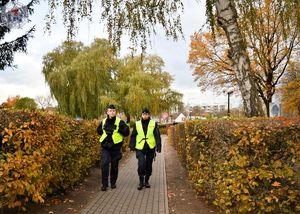 Zdjęcie kolorowe. Policjanci patrolują cmentarz