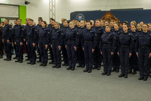 Zdjęcie kolorowe. Policjanci stoją w szeregu