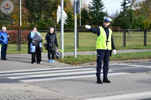 Zdjęcie kolorowe. Policjanci ruchu drogowego pełniący służbę w obrębie cmentarza