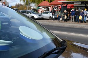 Zdjęcie kolorowe. Policjanci ruchu drogowego pełniący służbę w obrębie cmentarza