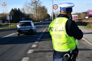 Zdjęcie kolorowe. Policjant ruchu drogowego podczas działań prędkość