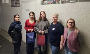 Zdjęcie kolorowe. Od lewej strony stoi policjantka, obok dwie uczennice a następnie, promotor zdrowia i pedagog