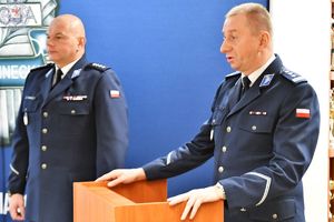 Zdjęcie kolorowe. Z lewej strony stoi I Zastępca Komendanta powiatowego a w centralnej części za mównica Komendant Powiatowy Policji w Szczecinku