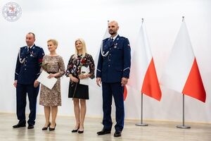 Zdjęcie kolorowe. Komendanci w obecności wyróżnionych pracowników Policji
